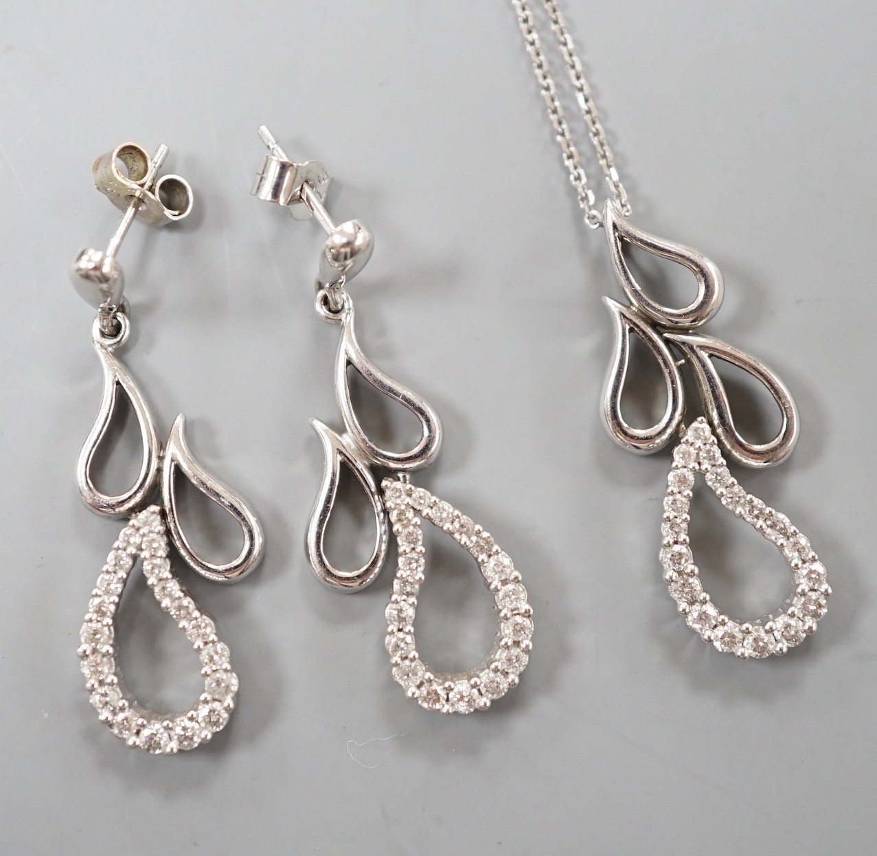 A modern white metal and diamond set quadruple teardrop shaped cluster drop pendant, 28mm, on a 9ct white gold fine link chain, 39cm and a pair of matching earrings, gross weight 7.6 grams.